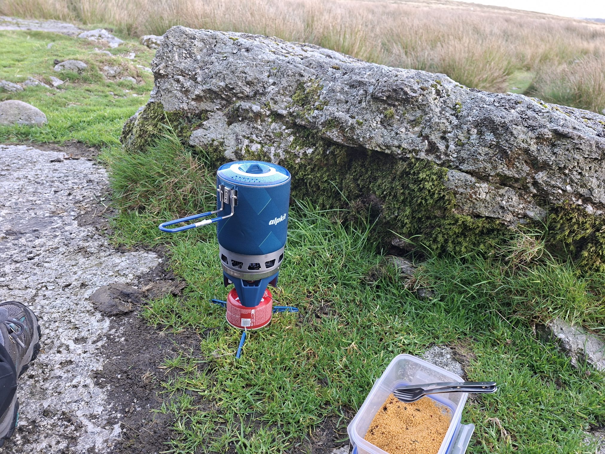 Camping stoke and Tupperware of food in a Dartmoor field.